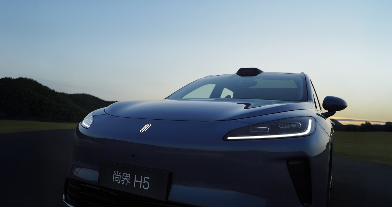Shangjie H5 Liquid Gold Black driving on an urban bend