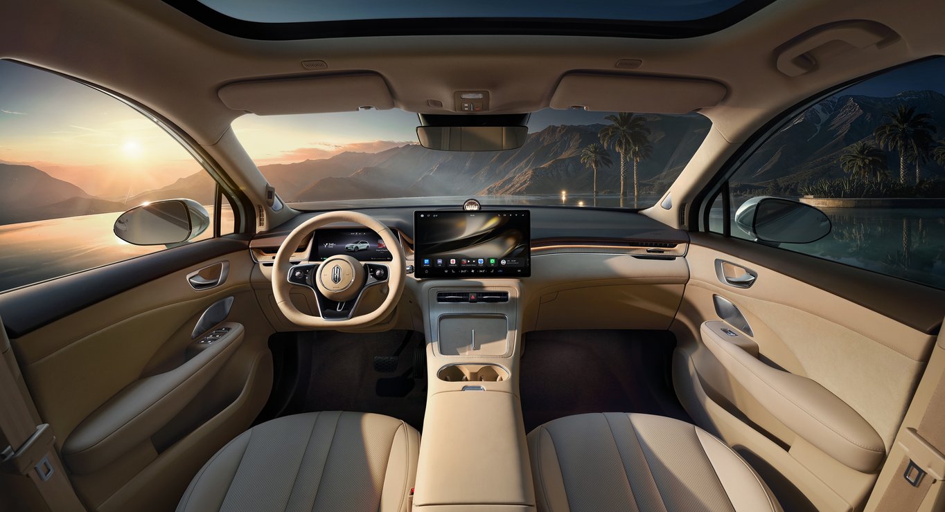 Front-row view of the Shangjie H5 Radiant Apricot interior, showcasing the double-layer wraparound cabin layout, central control screen, and steering wheel