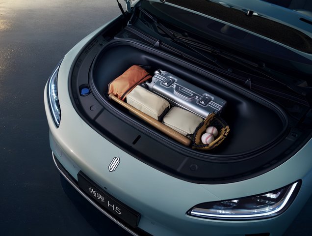 A carry-on case and sports equipment placed in the front trunk of the Shangjie H5