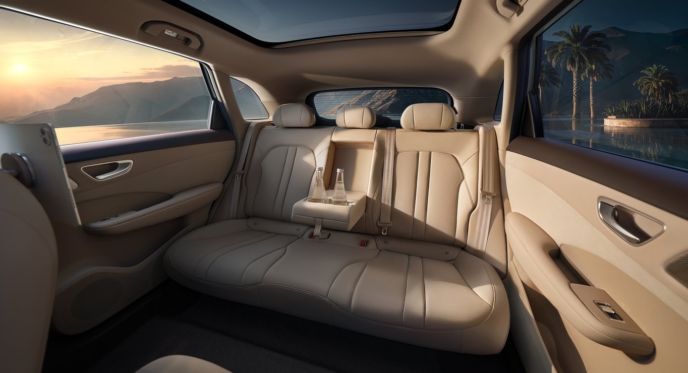 Rear-row view of the Shangjie H5 Radiant Apricot interior, showcasing the rear cabin layout and cup holders