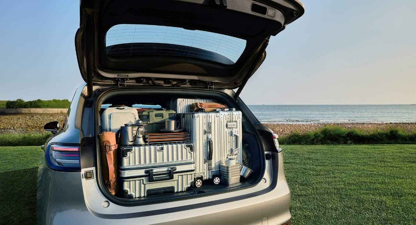 A child sitting in the rear trunk hidden compartment of the Shangjie H5, with toys stored beside it