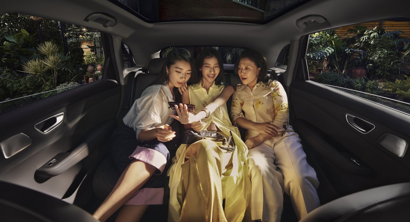 Three women sitting together in the rear row of the Shangjie H5, showcasing the spacious true 