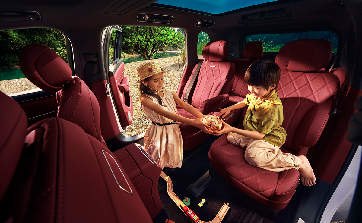 Two children sitting on the second-row seats of the AITO M8 in Nebula Red