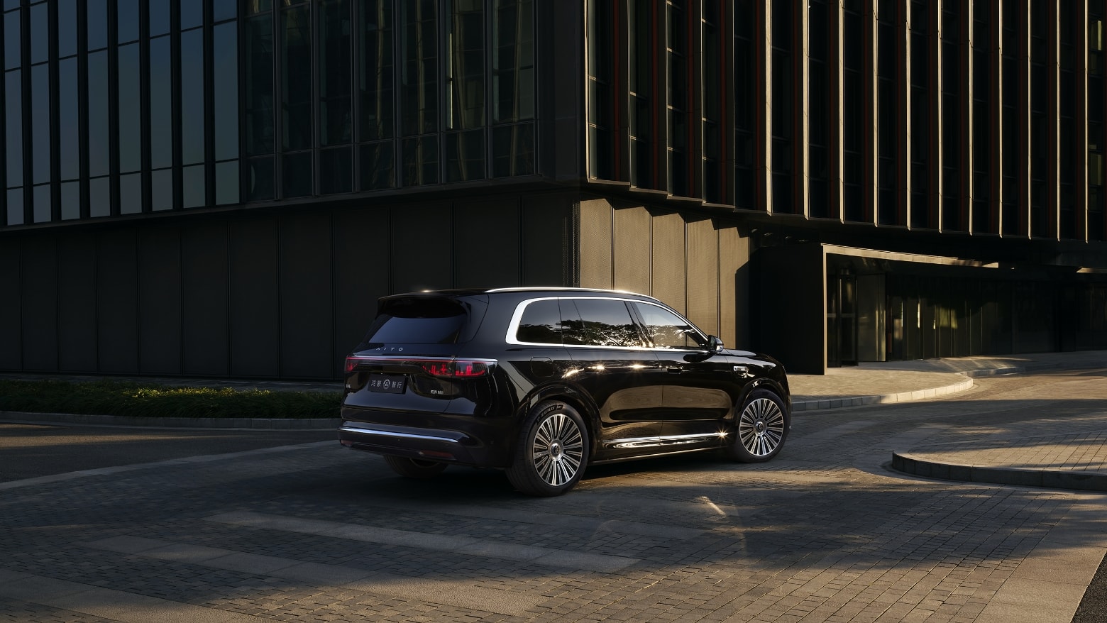 An AITO M8 in Lustrous Gold Black driving on a city road