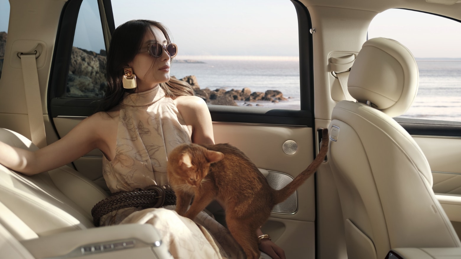 A woman resting inside the AITO M8 in White Sand Apricot