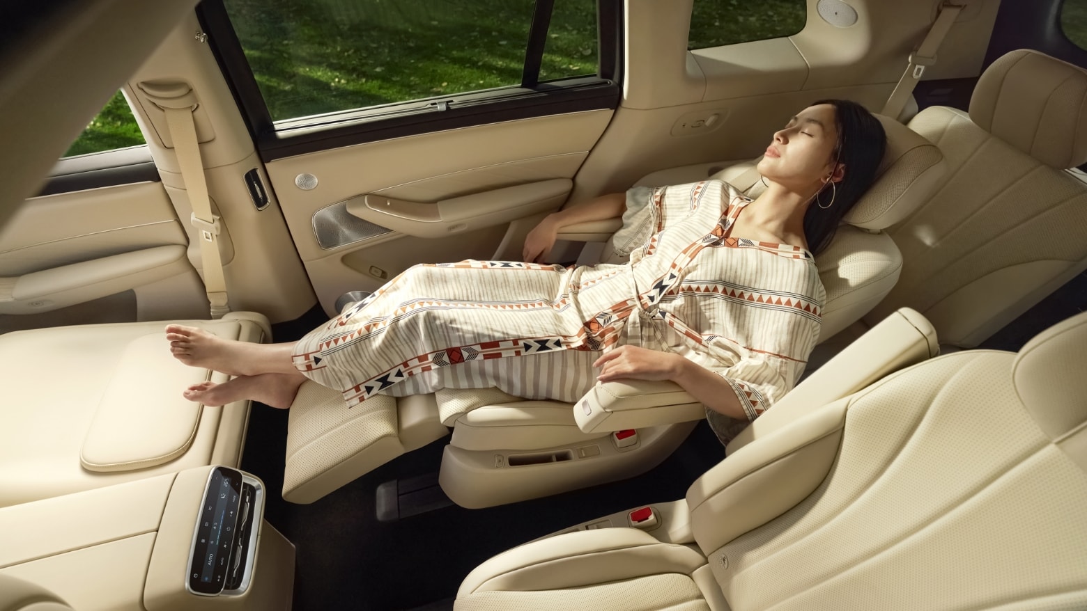 A woman lying on the unfolded second-row zero-gravity seat of the AITO M8 in White Sand Apricot