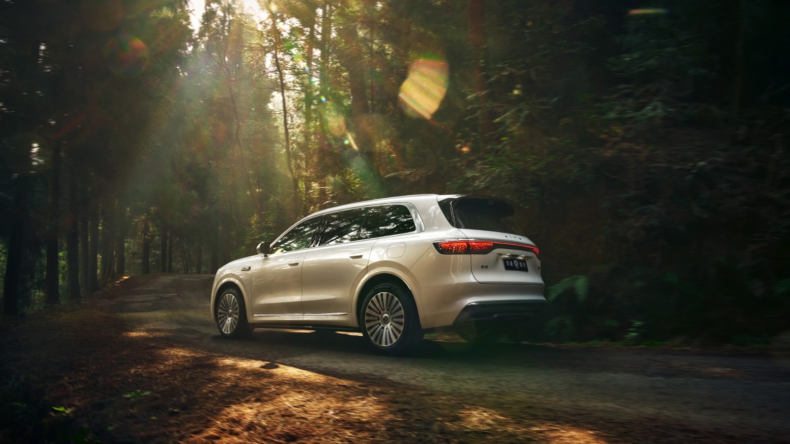 An AITO M8 in Warm Cloud White driving on a rough, uneven natural road