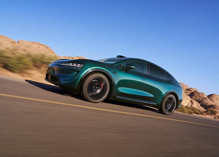 The Luxeed R7 driving on a curve, showing its active cornering control performance