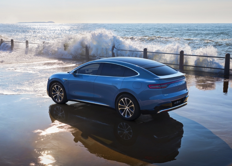 The Luxeed R7 driving on a flooded road surface, showing its active anti-slip control function