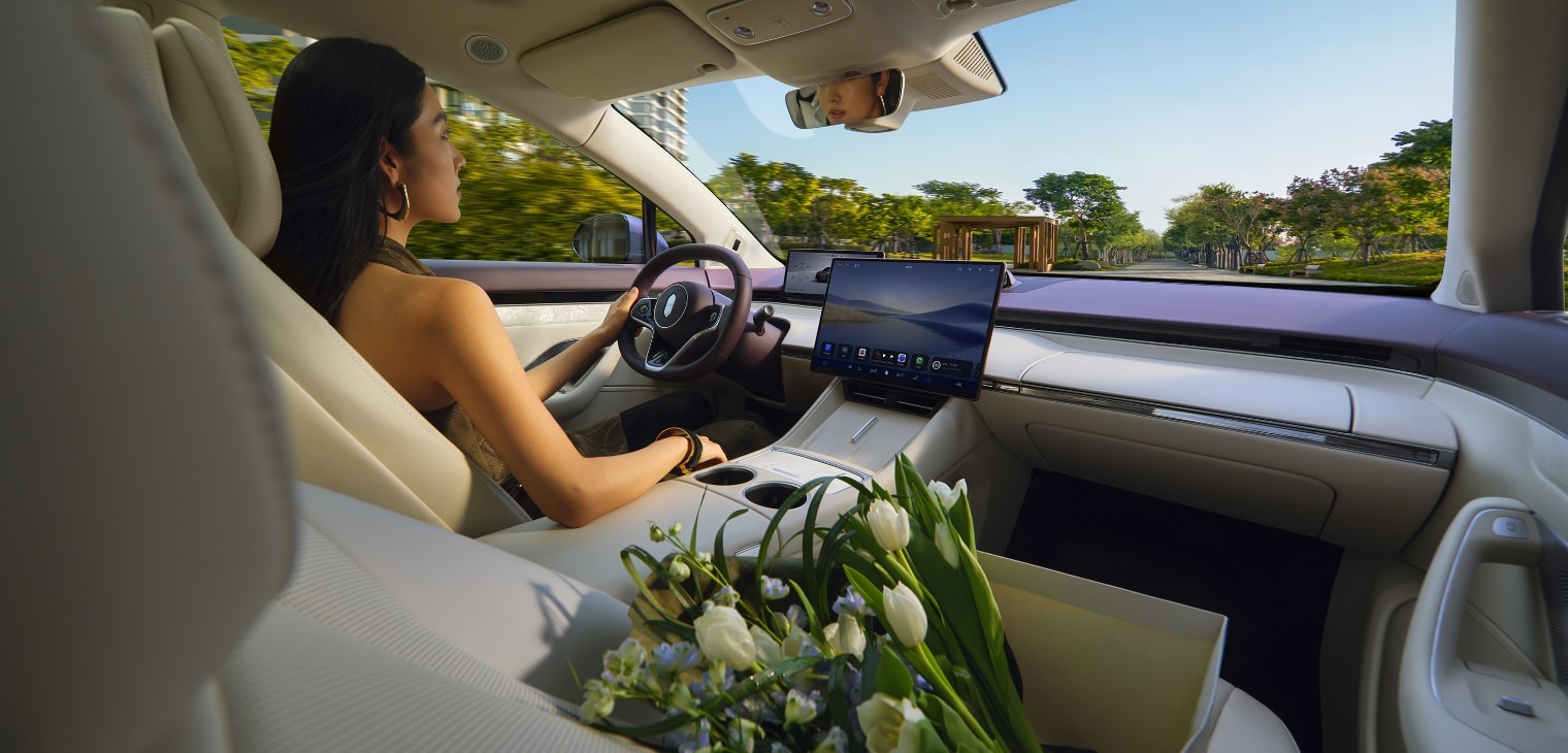 A woman driving the Luxeed R7 in a relaxed state, showing the comfortable cabin environment created by the car's tri-zone climate control