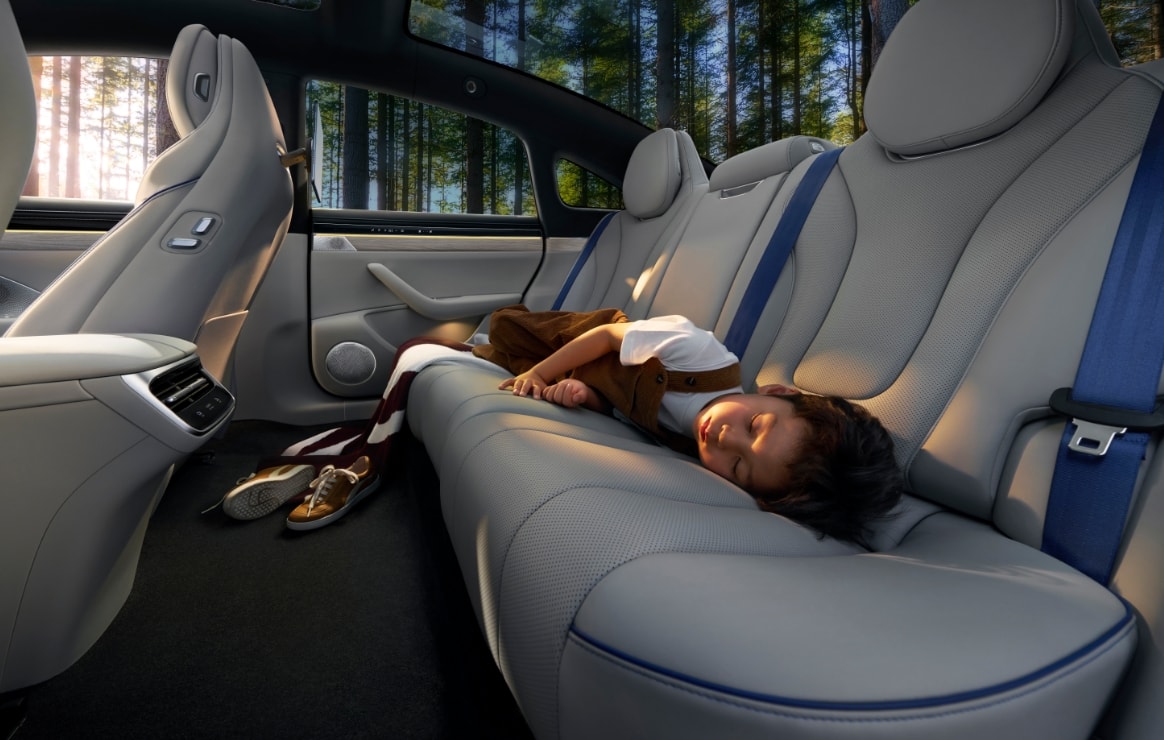 A user sleeping in the rear seat of the Luxeed New S7, showing the extra-large space of the Luxeed New S7