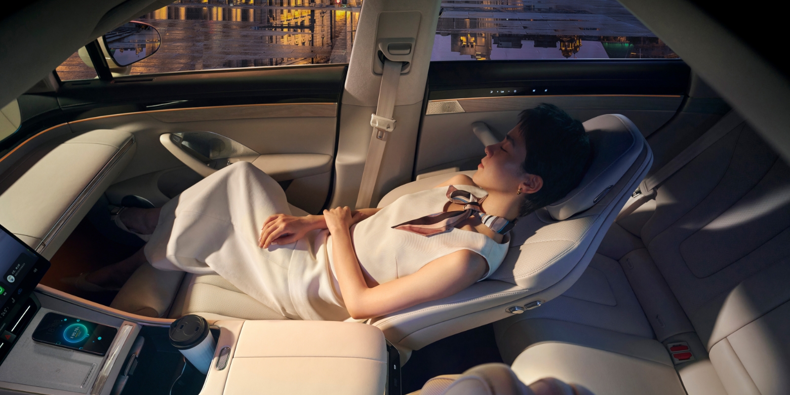 A user resting on the zero-gravity seat in the Luxeed New S7, showing the seat's comfort