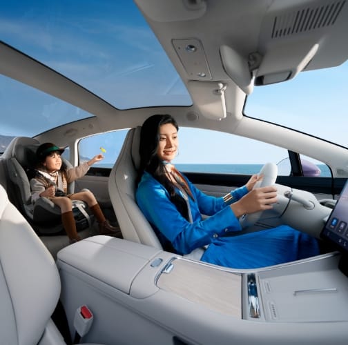A user driving the Luxeed New S7 with a child seated in a rear safety seat, showing the cabin's health and safety feature